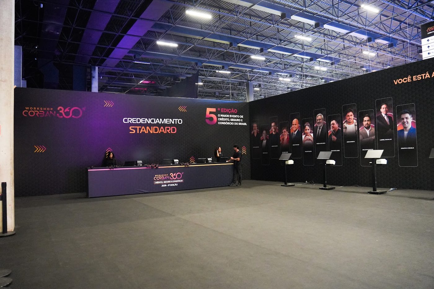 Stand com balcão de atendimento e painel iluminado em feira corporativa