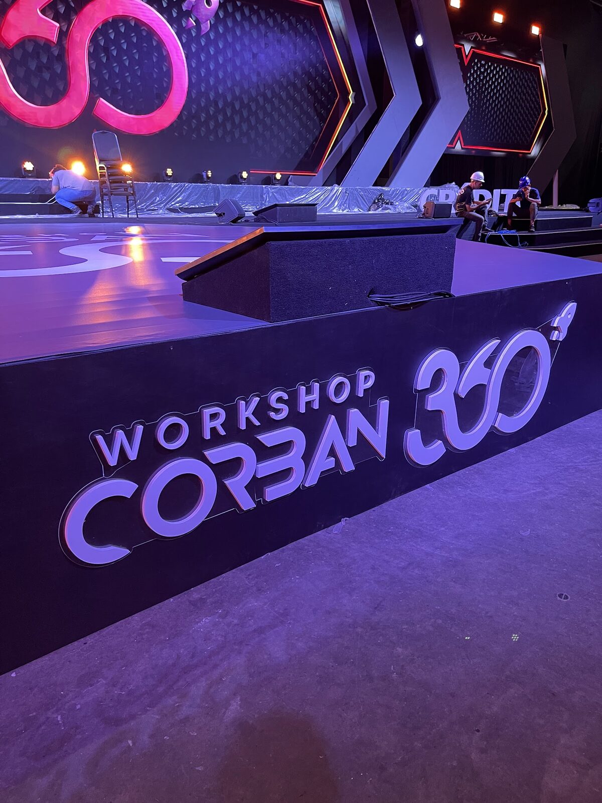 Bastidores de montagem de palco cenográfico com equipe técnica ajustando estrutura e iluminação