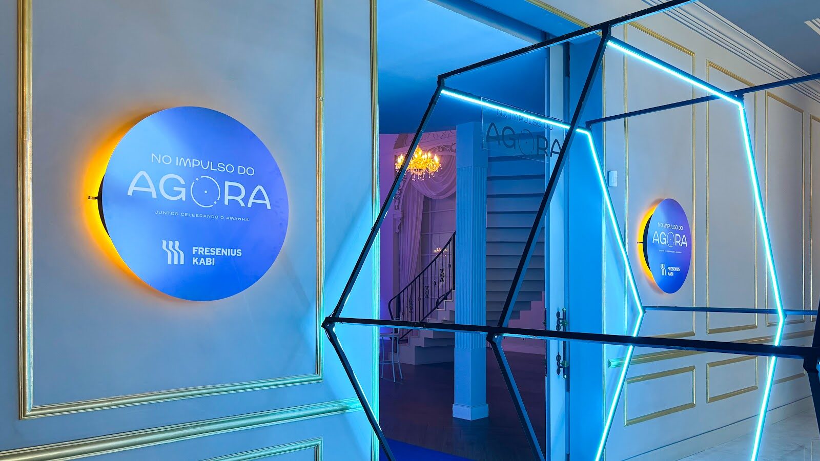 Entrada de salão com estrutura hexagonal neon e placas circulares luminosas Fresenius
