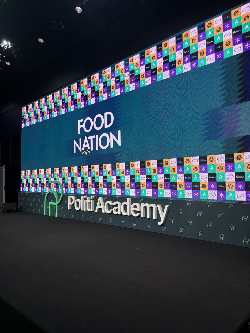 Palco cenográfico corporativo com painel de LED exibindo identidade visual do evento