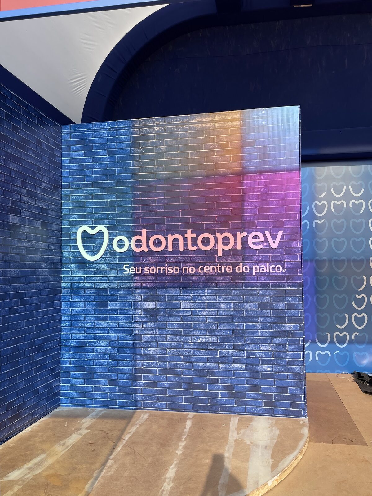 Painel cenográfico de tijolos coloridos com logo Odontoprev em fase de montagem no Festival Nômade
