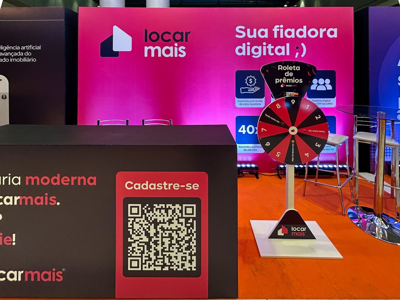 Estande rosa com roleta de prêmios e QR code em feira corporativa