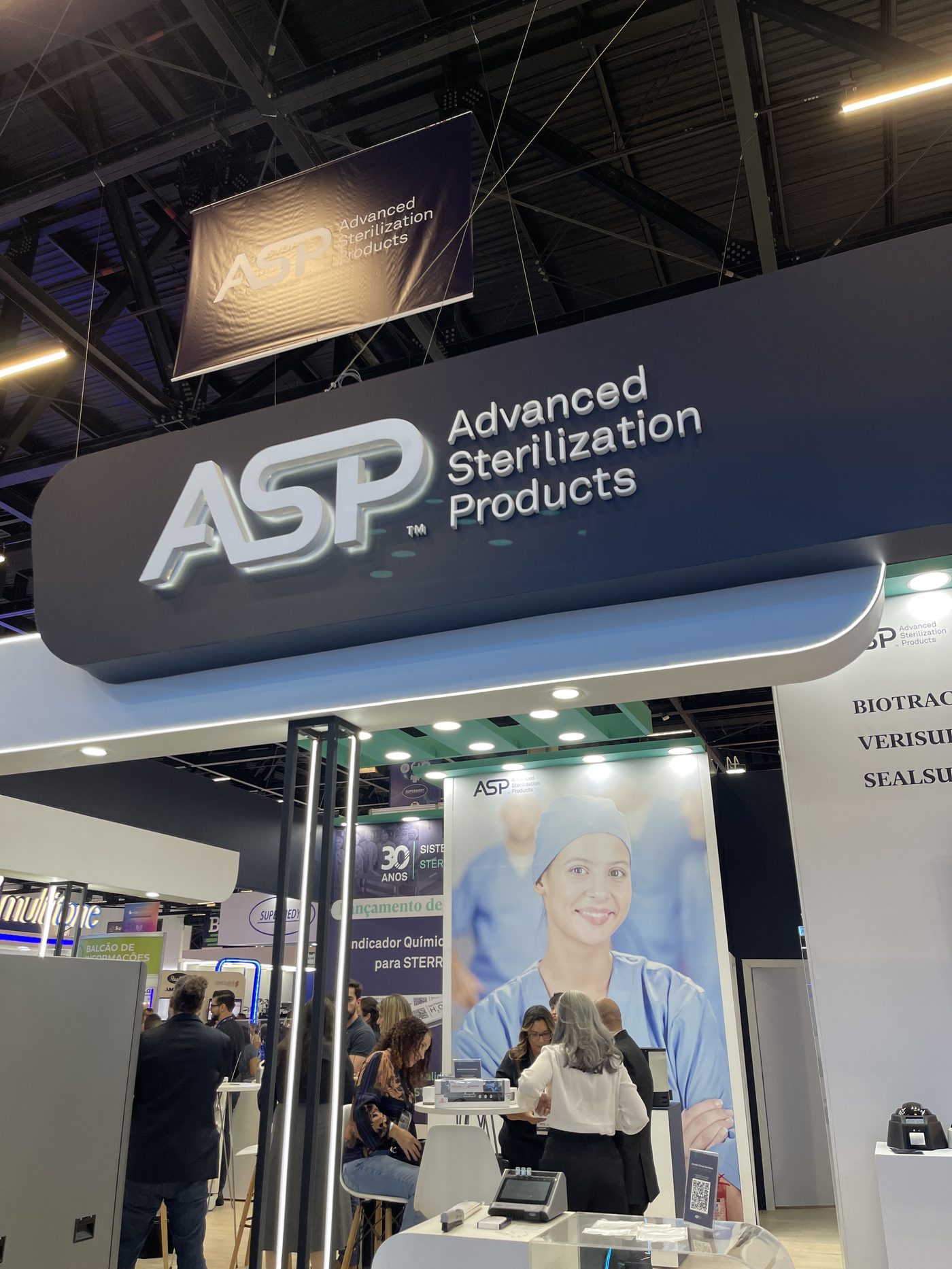 Testeira curva retroiluminada da ASP no estande da Feira Hospitalar, com logotipo em destaque